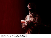 An armed soldier in military uniform holds a rifle in his hands on a black and red background, studio. Стоковое фото, фотограф Владимир Арсентьев / Фотобанк Лори