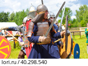 Pskov, Russia, July 10. 2022. Epic Invading Army of Medieval Knights on Battlefield, Plate Body Armored Soldiers with Swords in Battle Cry. Historical Reenactment. Редакционное фото, фотограф Ирина Старикова / Фотобанк Лори