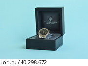 Pskov, Russia, August 03. 2022. Close up fashion image of Victorinox watch in a black box on a blue background. Редакционное фото, фотограф Ирина Старикова / Фотобанк Лори