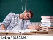 Young male teacher suffering in the classroom. Стоковое фото, фотограф Elnur / Фотобанк Лори