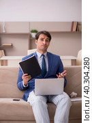 Young male employee working from home during pandemic. Стоковое фото, фотограф Elnur / Фотобанк Лори