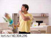 Young man doing housework indoors. Стоковое фото, фотограф Elnur / Фотобанк Лори