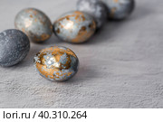 Stylish grey Easter eggs made of marble and concrete with a golden potala on a grey background. Coloring eggs with natural dye karkade tea. Environmental friendliness. Naturalness. The concept of a happy Easter. Стоковое фото, фотограф Photojuli / Фотобанк Лори