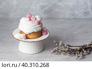 Beautiful stylish still life. Easter cake with meringue, marshmallows, Easter eggs and willow twigs on a light concrete background. happy Easter. Стоковое фото, фотограф Photojuli / Фотобанк Лори