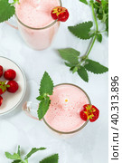 Milkshake with strawberries in a glass glass with melissa leaves in the design, top view. Стоковое фото, фотограф Неведицына Елена / Фотобанк Лори