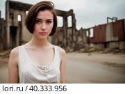 A young woman with dark brown hair against the background of the city ruins. Generative AI. Стоковое AI-изображение, AI-художник Mixail59 / Фотобанк Лори