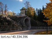 View of the arch "Big Caprice" over the Podkaprizovaya road in the Alexander Park of Tsarskoye Selo on a sunny autumn day, Pushkin, St. Petersburg, Russia. Стоковое фото, фотограф Ula Ulachka / Фотобанк Лори