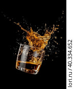 Cognac splashes in a transparent glass on a dark background. Стоковое AI-изображение, AI-художник Ярославский Максим / Фотобанк Лори