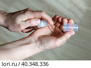 Руки выдавливают гель антисептик на ладонь из компактного флакона. Стоковое фото, фотограф Vladimir Vikhrov / Фотобанк Лори