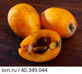 Whole and half fresh yellow loquat on wooden table. Стоковое фото, фотограф Яков Филимонов / Фотобанк Лори