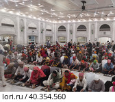 Паломники в благотворительной столовой в храме Gurudwara Sri Bangla Sahib (Нью Дели, Индия) (2023 год). Редакционное фото, фотограф Максим Гулячик / Фотобанк Лори