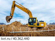 Excavator dig the trenches at a construction site. Trench for laying external sewer pipes. Sewage drainage system for a multi-story building. Digging the pit foundation. Стоковое фото, фотограф Дмитрий Головач / Фотобанк Лори
