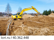 Excavator dig the trenches at a construction site. Trench for laying external sewer pipes. Sewage drainage system for a multi-story building. Digging the pit foundation. Стоковое фото, фотограф Дмитрий Головач / Фотобанк Лори