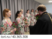 Настоятель храма священник Михаил Куземка дарит цветы участникам хора «Душа» в Николо-Архангельском храме города Балашиха (2023 год). Редакционное фото, фотограф Дмитрий Неумоин / Фотобанк Лори