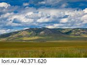 Rural settlement in the steppe at the foot of the mountains. Dramatic sky over the hills of Khakassia, Russia. Стоковое фото, фотограф Оксана Прахова / Фотобанк Лори