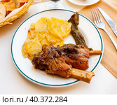 Roasted calcots, sweet onions typical of Catalonia, Spain, and an bowl with romesco sauce to dip them. Стоковое фото, фотограф Яков Филимонов / Фотобанк Лори