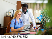 Two focused doctors discussing medical histories of patients. Стоковое фото, фотограф Яков Филимонов / Фотобанк Лори