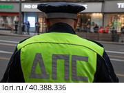 Сотрудник ДПС стоит на посту на Тверской улице в центре города Москвы и обеспечивают безопасность движения на дороге, Россия (2023 год). Редакционное фото, фотограф Николай Винокуров / Фотобанк Лори
