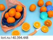 Апельсины в коробке и рассыпанные на столе и круглые светильники на голубом фоне, натюрморт. Стоковое фото, фотограф Татьяна Бакуменко / Фотобанк Лори