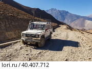 A broken car stands on a gravel road. Jeep gravel road from Jomsom to Muktinath in the Himalayas. Jharkot, Mustang District, Nepal (2016 год). Редакционное фото, фотограф Михаил Пряхин / Фотобанк Лори