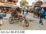 A rickshaw stands on Kathmandu Street. In Nepal transport such as pedicabs is still common. Kathmandu, Nepal (2016 год). Редакционное фото, фотограф Михаил Пряхин / Фотобанк Лори