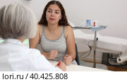 Positive young woman patient discussing face aesthetic procedures with a specialist in doctor cabinet. Стоковое видео, видеограф Яков Филимонов / Фотобанк Лори