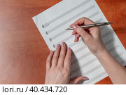 Рукописные ноты и скрипичный ключ. Лист бумаги с нотами. Женские руки на листе с нотным станом. Изучение темы сольфеджио. Стоковое фото, фотограф Руслан Лесков / Фотобанк Лори