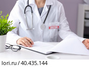 A doctor in a white coat with a pharyngoscope sits in a medical office. Стоковое фото, фотограф Alexandra Aleroewa / Фотобанк Лори