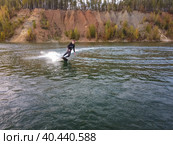 Motosurf Competitor taking corner at speed making a lot of spray. Jet surfing on a water, man riding on jet surfboard. Surfer in motion, summer sport. Стоковое фото, фотограф Олег Спиридонов / Фотобанк Лори