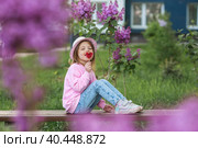 Lifestyle. A beautiful little girl in pink clothes with a lollipop in the shape of a heart. The girl licks the candy. The concept of love and sweets. Стоковое фото, фотограф Photojuli / Фотобанк Лори