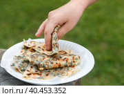 Gozleme. A traditional dish of Turkish cuisine in the form of flatbread stuffed with greens and cheese, wrapped inside. Baked in a pan called a saj. Selective focus. Стоковое фото, фотограф Виктория Панченко / Фотобанк Лори