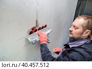 The electrician will plaster holes and channels for sockets and wires. Стоковое фото, фотограф Юрий Поздников / Фотобанк Лори