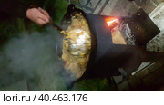 A man's hand is stirring ready pilaf in a saucepan with a spoon. Party in nature. Стоковое видео, видеограф Юрий Поздников / Фотобанк Лори
