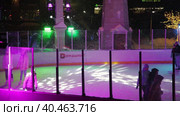 People skate in the evening on a lighted ice rink. A blizzard is raging and snow is falling. Zelenograd, Russia 28.01.2022. Редакционное видео, видеограф Юрий Поздников / Фотобанк Лори