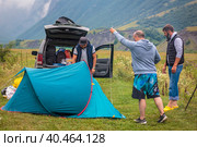 A company of friends is resting in the mountains, setting up a tent. Mountains of the Caucasus. Russia Ossetia Vladikavkaz August 15, 2020. Стоковое фото, фотограф Юрий Поздников / Фотобанк Лори