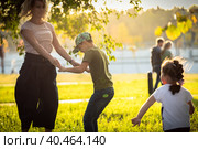 Mom plays and dances with children in the park, laughs and spins with happiness. Russia Moscow September 24, 2020. Редакционное фото, фотограф Юрий Поздников / Фотобанк Лори