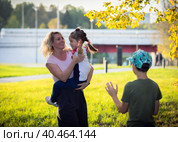 Mom plays and dances with children in the park, laughs and spins with happiness. Russia Moscow September 24, 2020. Редакционное фото, фотограф Юрий Поздников / Фотобанк Лори