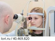 A male ophthalmologist checks the eyesight of a young girl using a modern device with a light beam. Стоковое фото, фотограф Юрий Поздников / Фотобанк Лори