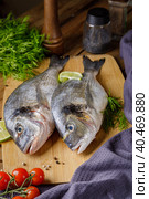 Raw peeled dorado fish with cooking ingredients. Fresh fish on a wooden background. Стоковое фото, фотограф Юрий Поздников / Фотобанк Лори