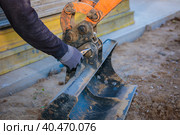 A man repairs a tractor bucket, changes the mounting sleeve. Replacing the nozzle on the tractor boom. Close-up. Стоковое фото, фотограф Юрий Поздников / Фотобанк Лори