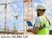 Drone operated by safety engineering inspector. Construction worker piloting drone on building site. Стоковое фото, фотограф Дмитрий Калиновский / Фотобанк Лори