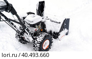 Snowblower removes snow, a man cleans the yard outside. Стоковое фото, фотограф Igor Skripachev / Фотобанк Лори