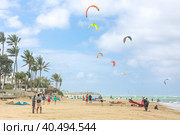Crowd of active sporty people enjoying kitesurfing holidays and activities on perfect sunny day on Cabarete tropical sandy beach in Dominican Republic. Стоковое фото, фотограф Matej Kastelic / Фотобанк Лори