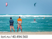 Active sporty people enjoying kitesurfing holidays and activities on perfect sunny day on Cabarete tropical sandy beach in Dominican Republic. Стоковое фото, фотограф Matej Kastelic / Фотобанк Лори