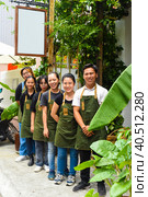 Vietnamese coffee shop team smiling and standing together against a cafe. Стоковое фото, фотограф Татьяна Терехина / Фотобанк Лори