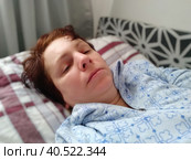 Sick woman in bed. Headache, runny nose and cold. Paleness of the face and faintness of the body. Feeling unwell. The patient lies on a pillow. Loss of consciousness or shock. Стоковое фото, фотограф Юлия Петровская / Фотобанк Лори