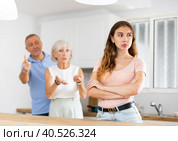 Upset adult daughter happens to reproach parents in kitchen. Стоковое фото, фотограф Яков Филимонов / Фотобанк Лори