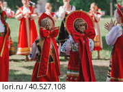 Russian folk traditions. Folk festivals. Children in beautiful Russian traditional outfits sing songs, dance and lead a round dance in Tsaritsyno Park. National Russian clothes. Sundresses and kokoshniks. (2023 год). Редакционное фото, фотограф Photojuli / Фотобанк Лори