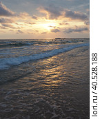 Wave and sunset over sea. Beautiful sunset. Foamy waves roll over the sandy shore. Vityazevo, Anapa, Black Sea. Tourist mecca, health resort. Evening sky. The rays reflect off the water. Стоковое фото, фотограф Юлия Петровская / Фотобанк Лори