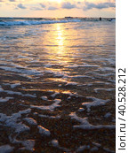 Sunset over sea. Beautiful sunset. Foamy waves roll over the sandy shore. Vityazevo, Anapa, Black Sea. Tourist mecca, health resort. Colorful clouds in the evening sky. The rays reflect off the water. Стоковое фото, фотограф Юлия Петровская / Фотобанк Лори